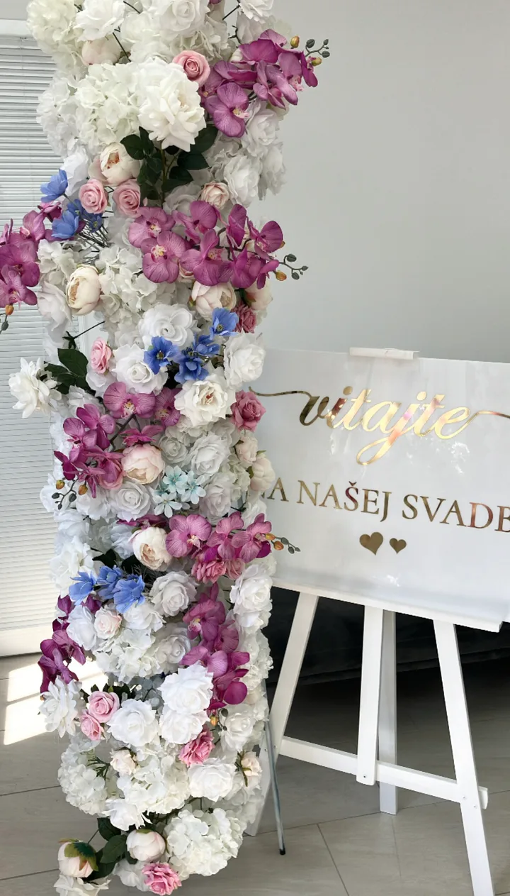 Kvetinový stojan s orchideami a uvítacia tabuľa